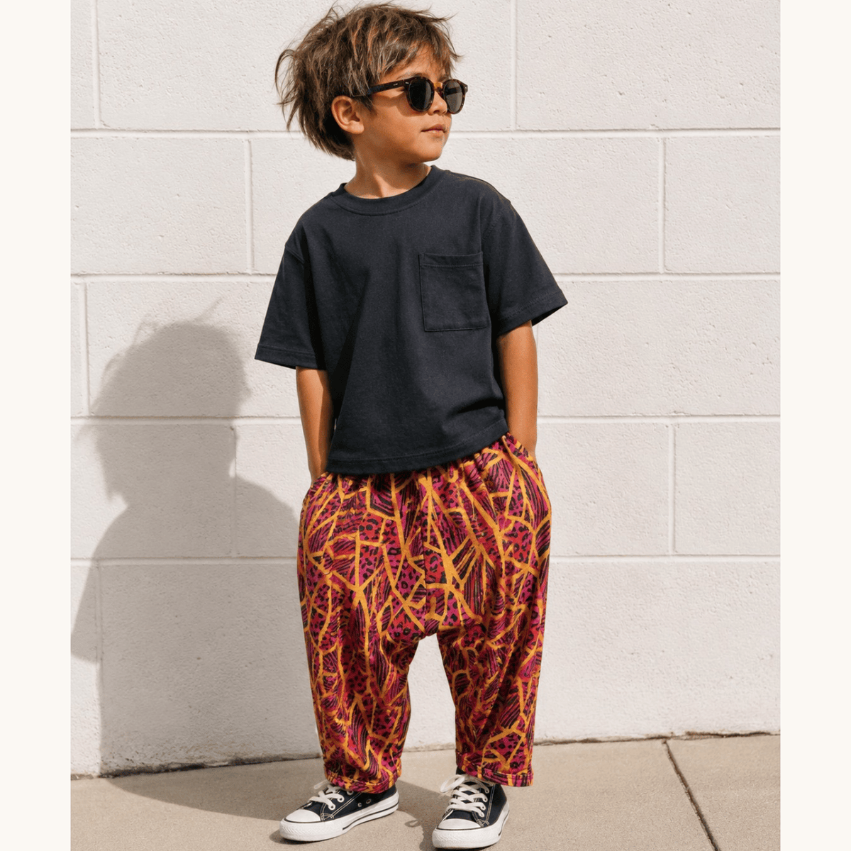 Kid in sunglasses and a black tee wearing the Neon Jungle Hammer Pant