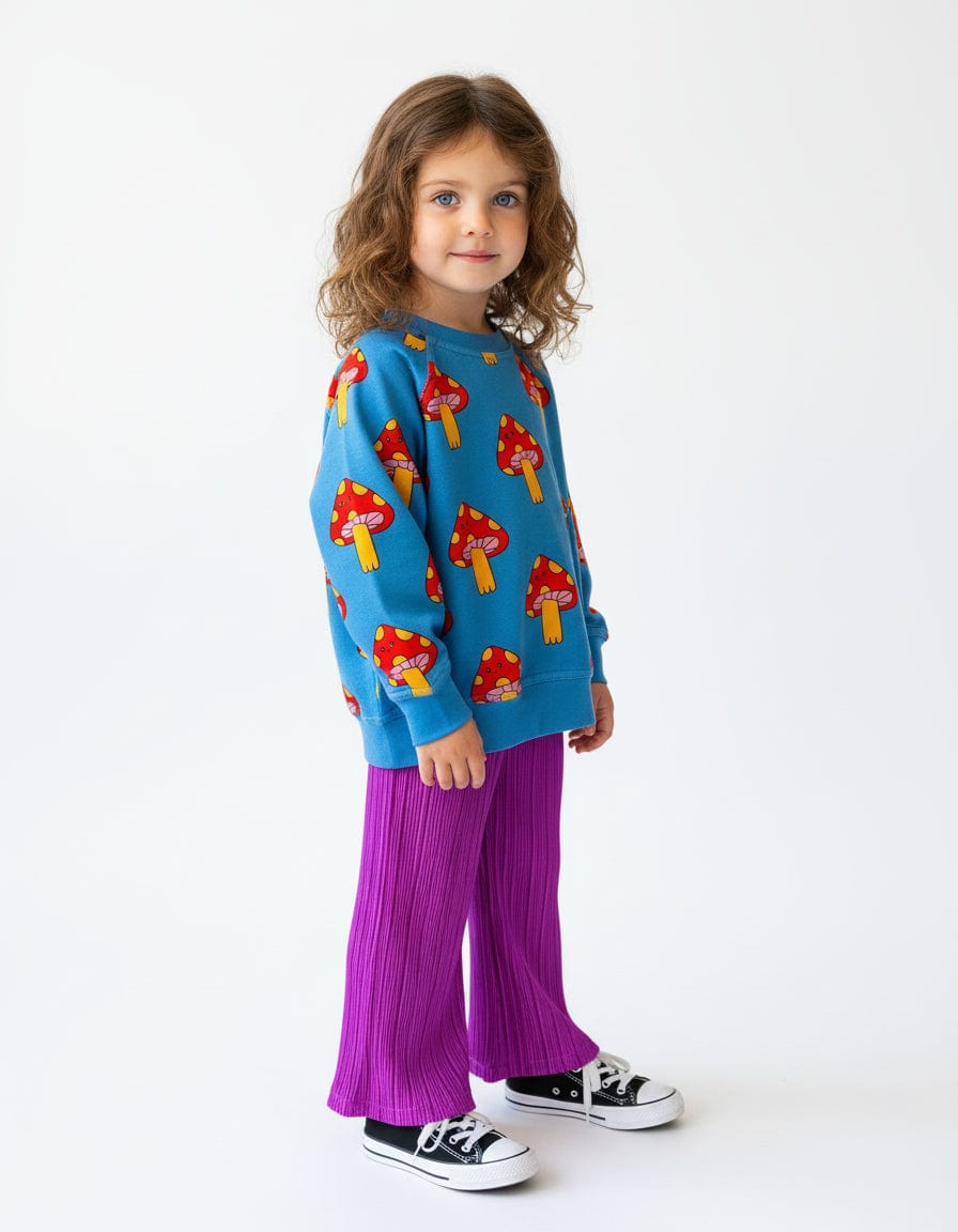 Kid in the Mellow Mushroom Pullover with purple wide-leg pants and sneakers