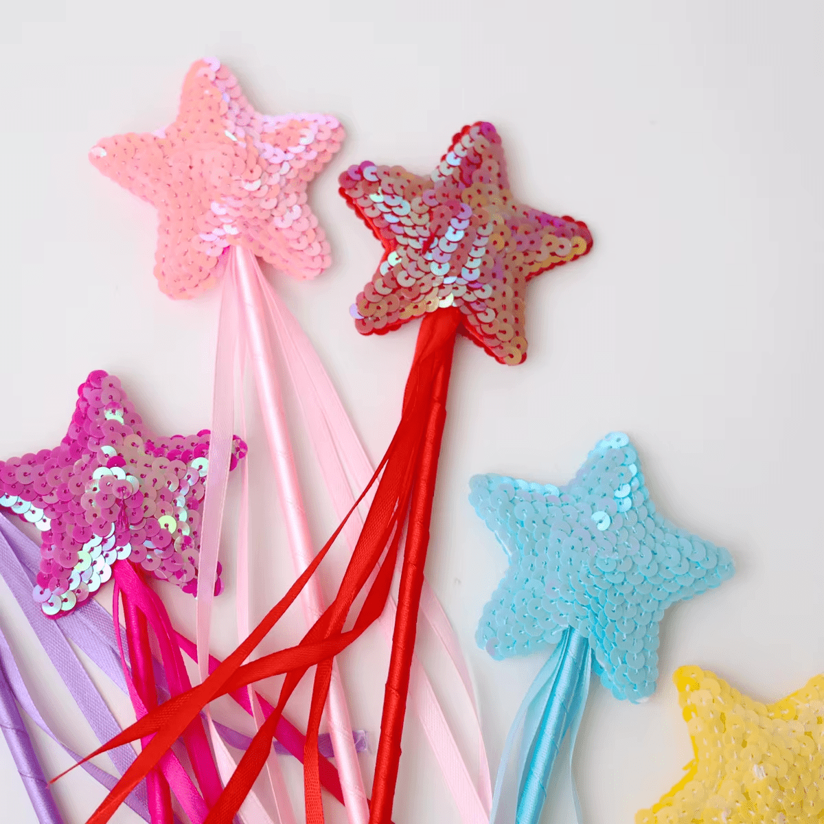 Sequin star fairy wands in pink, red, blue and yellow with ribbons