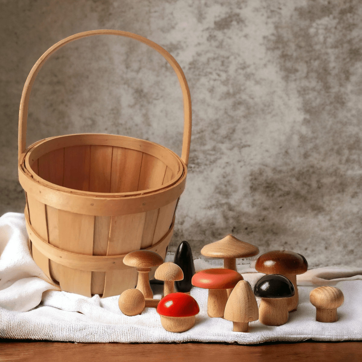 Handpainted wooden mushrooms in red, black and natural wood beside a woven basket