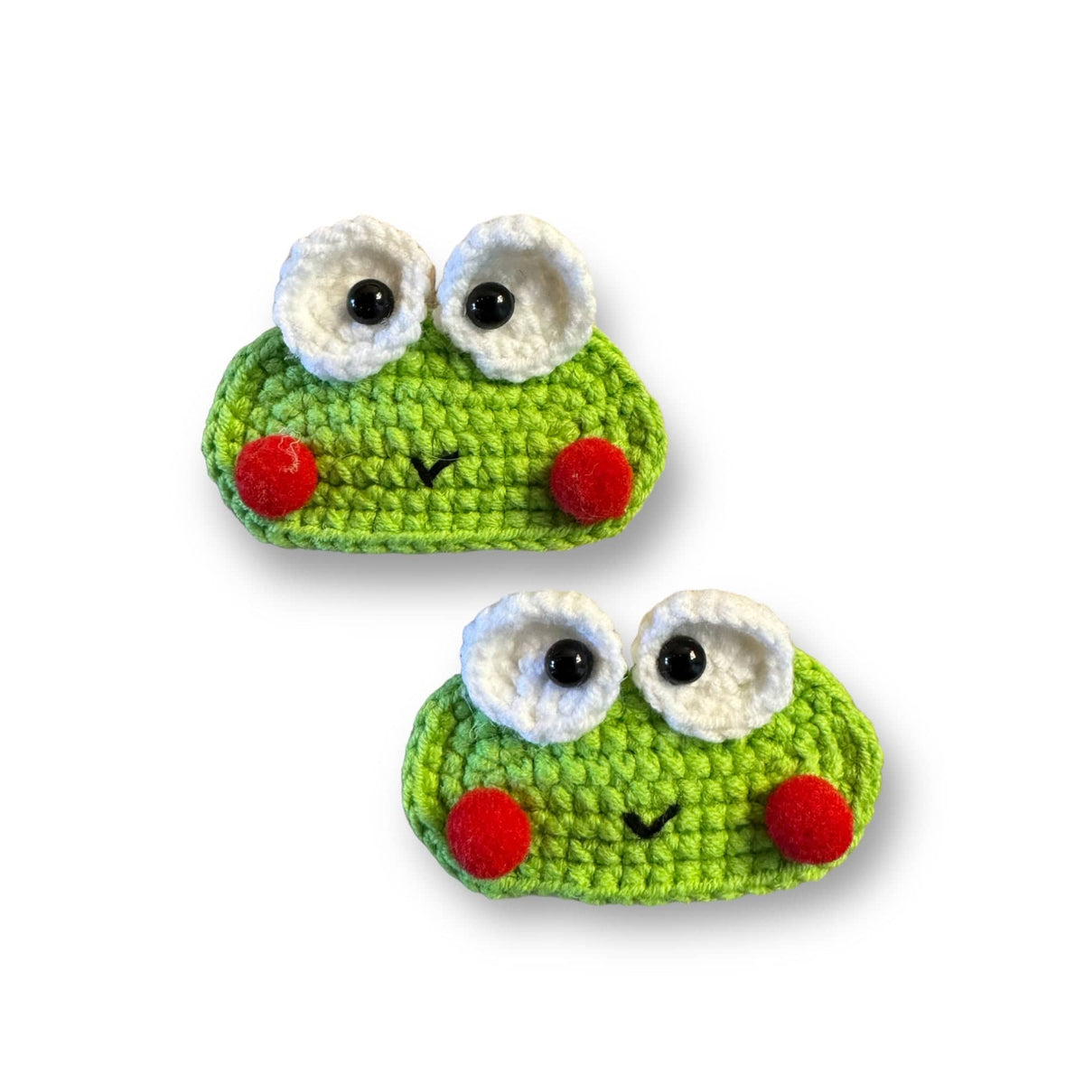 Two hand-crocheted green frog hair clips with rosy red cheeks