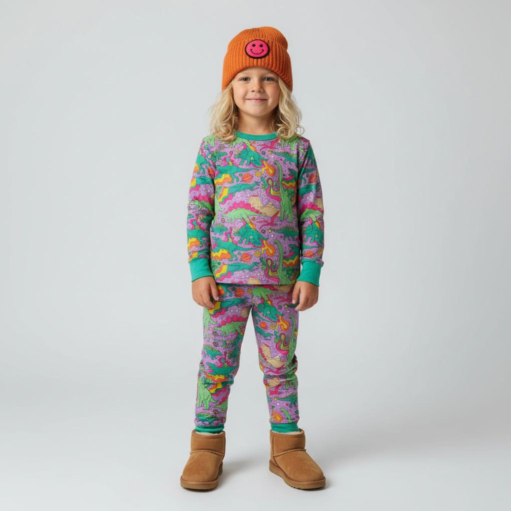 Kid in an orange beanie and boots wearing the Groovy Saurus PJ Set