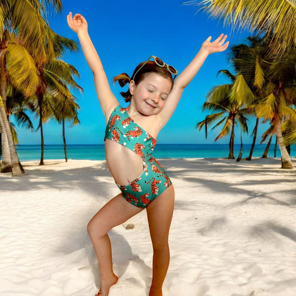 Kid dancing on a beach in the Easy Tiger Reversible Swimsuit