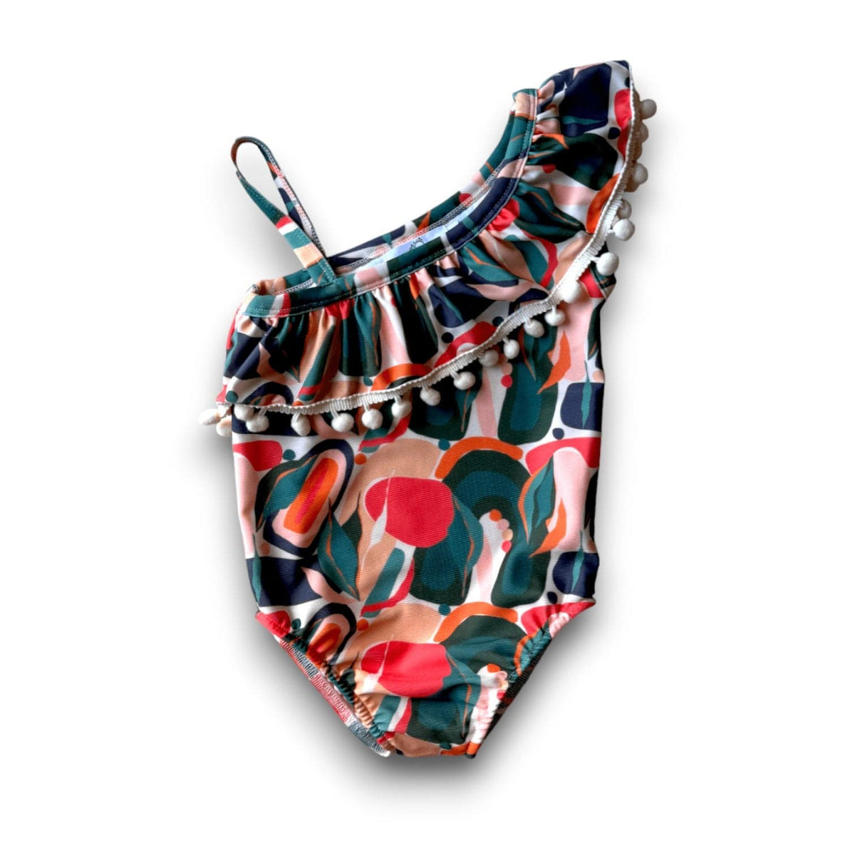 I Heart Pom-Poms one-shoulder swimsuit in the Mad Men print, pink, red and green shapes on dark green, with a pom-pom ruffle