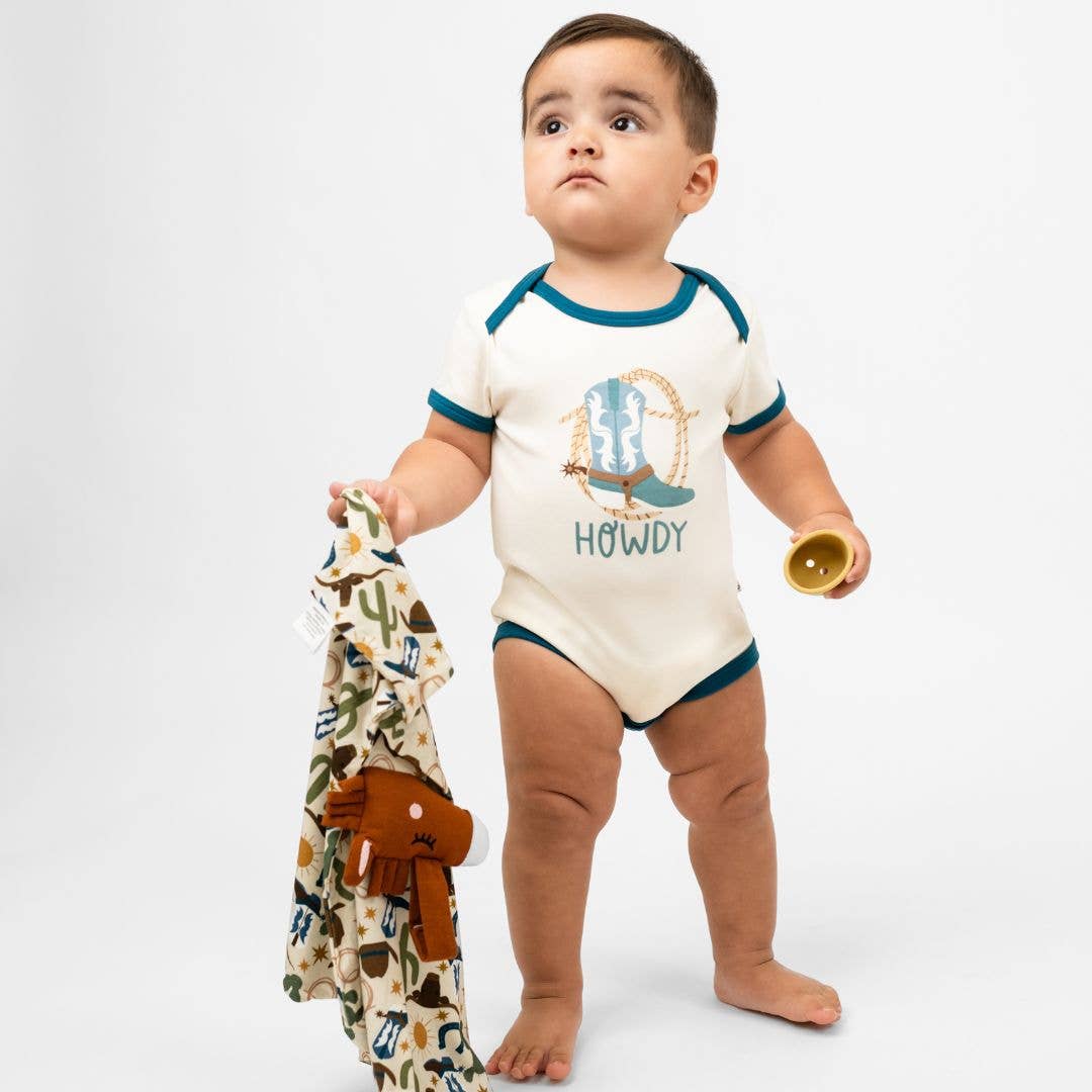 Baby in a Howdy bodysuit holding the horse lovey