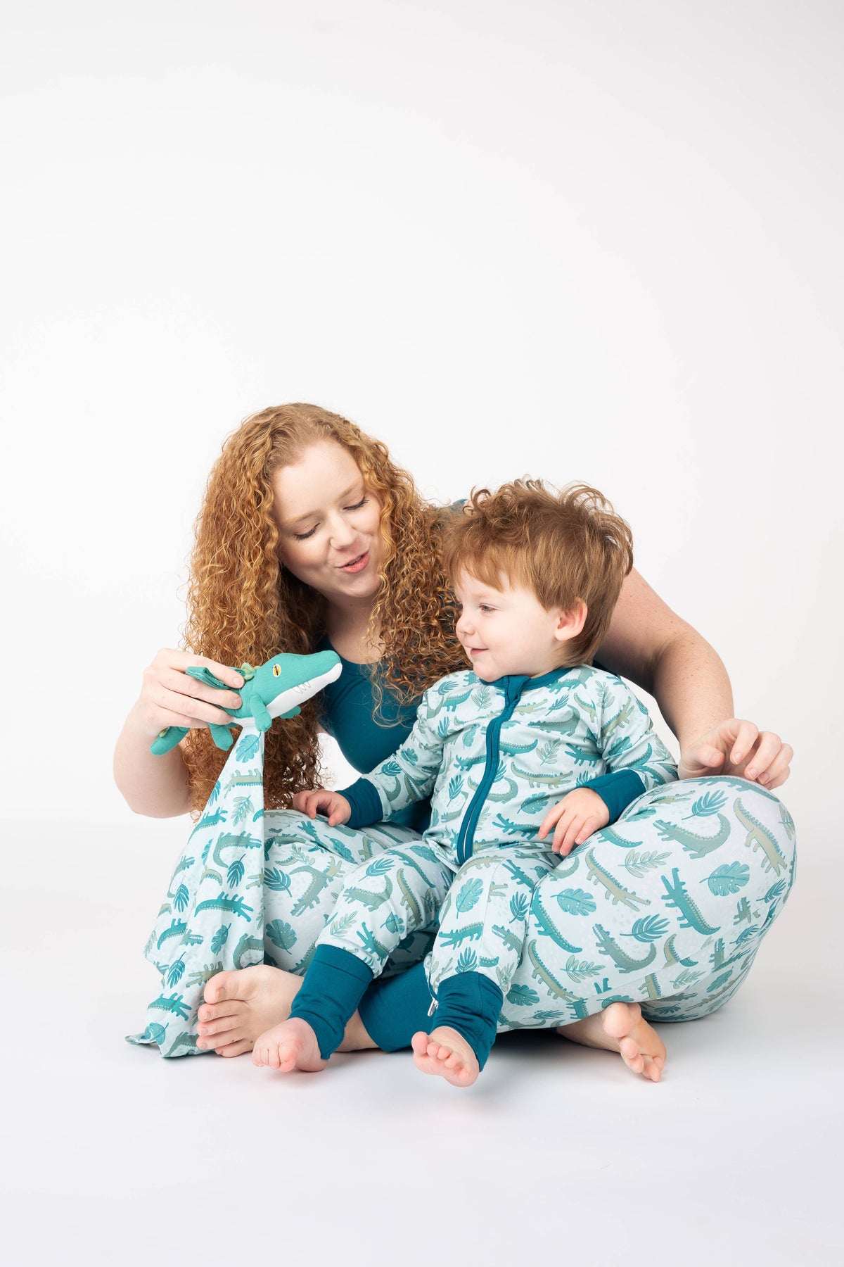 Mom and toddler in matching alligator print pajamas with the lovey
