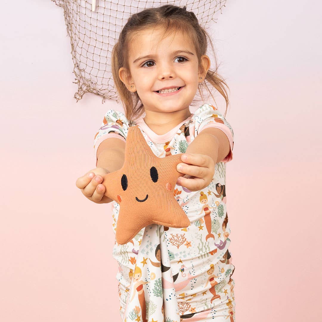 Smiling girl holding up the starfish lovey