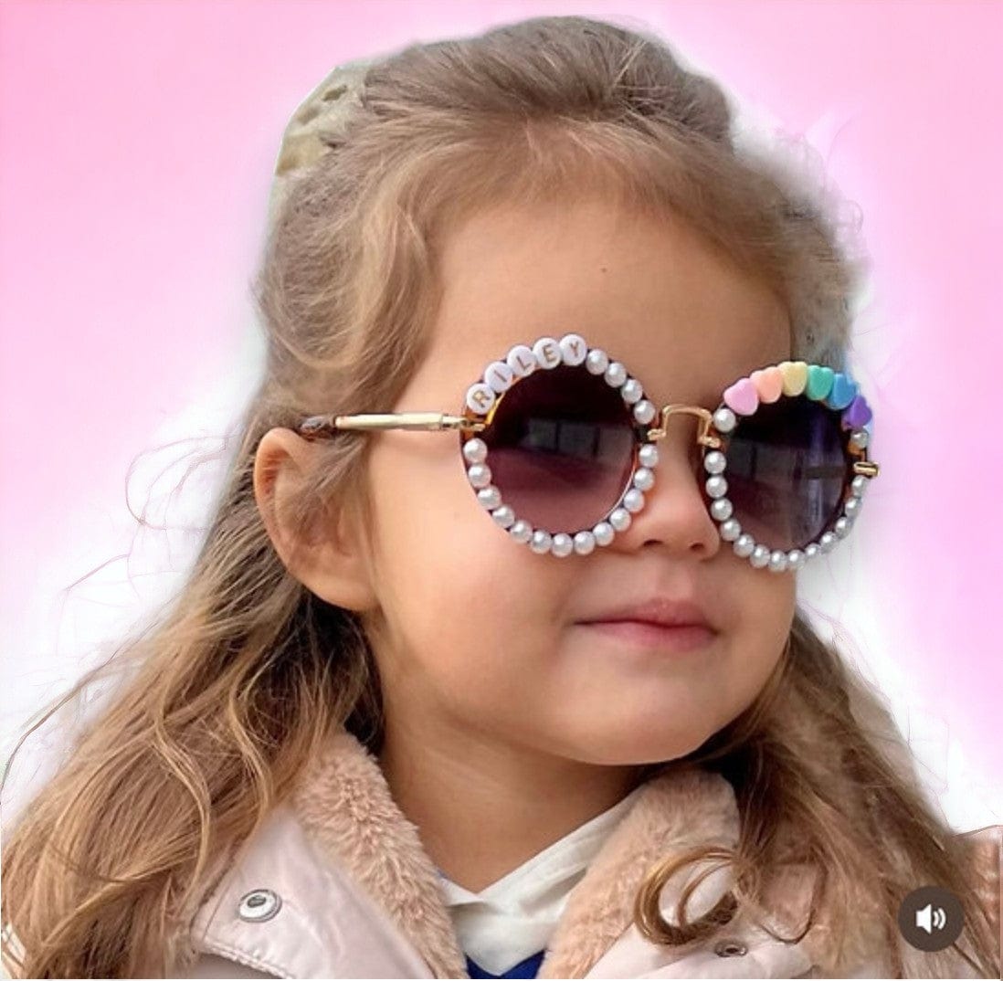 Smiling girl wearing pearl-trimmed personalized sunglasses